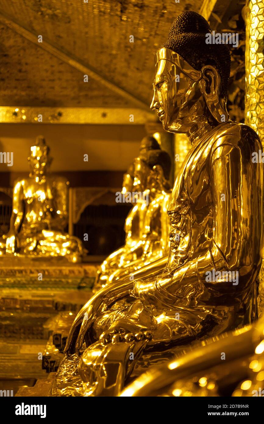 Yangon, Myanmar - 30. Dezember 2019: Eine Reihe von goldenen Buddha-Statuen, die in der Shwedagon Pagode sitzen Stockfoto