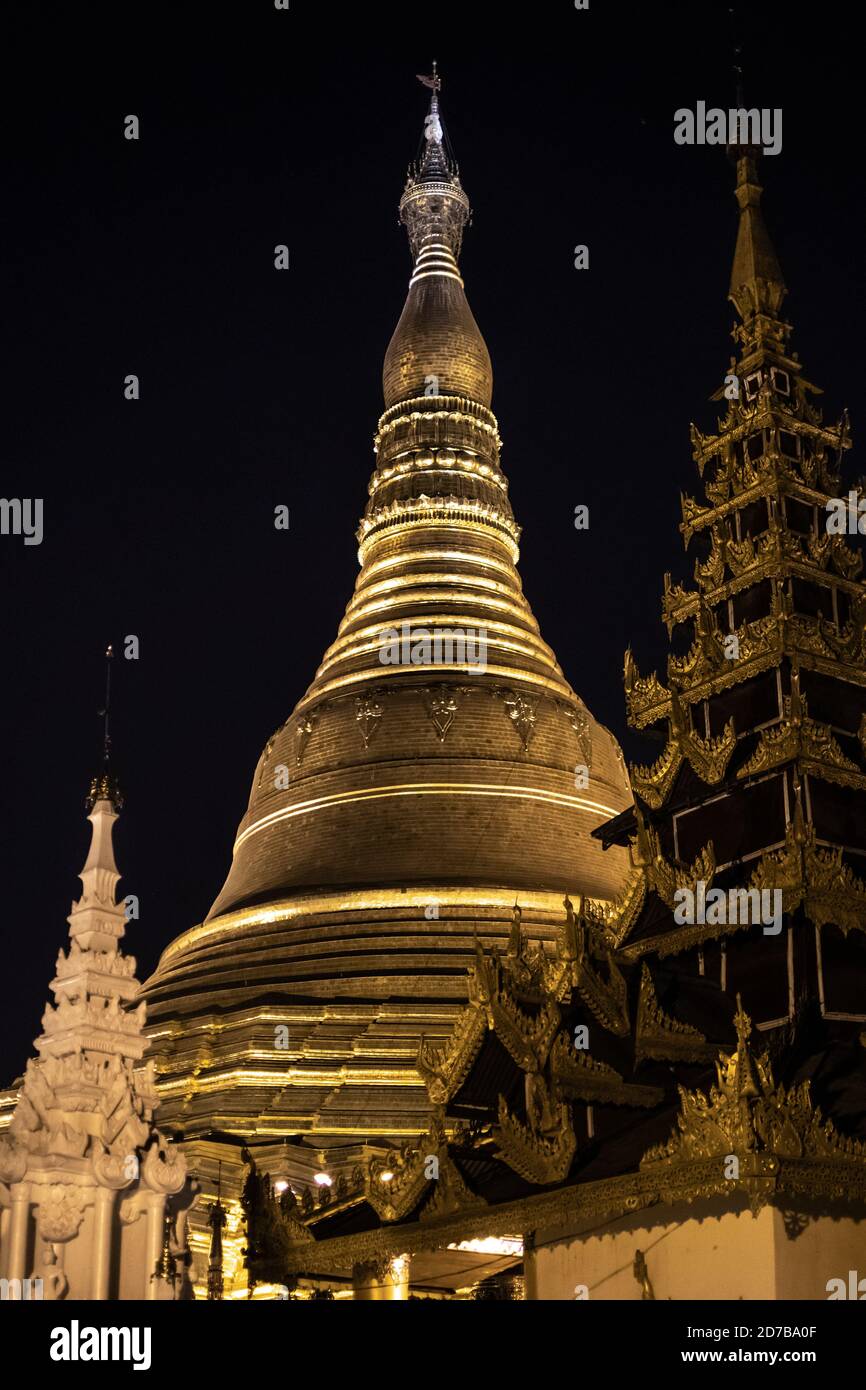 Yangon, Myanmar - 30. Dezember 2019: Die Spitze von zwei goldenen Strukturen gegen den dunklen Nachthimmel an der Shwedagaon Pagode Stockfoto