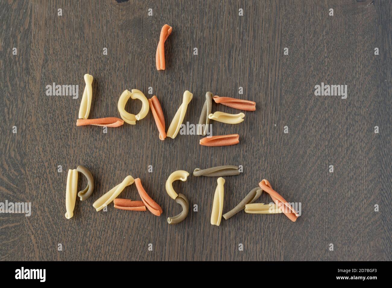 Ich liebe Pasta geschrieben mit tricolor caserecce italienische Pasta auf einem Holztisch, Draufsicht Stockfoto