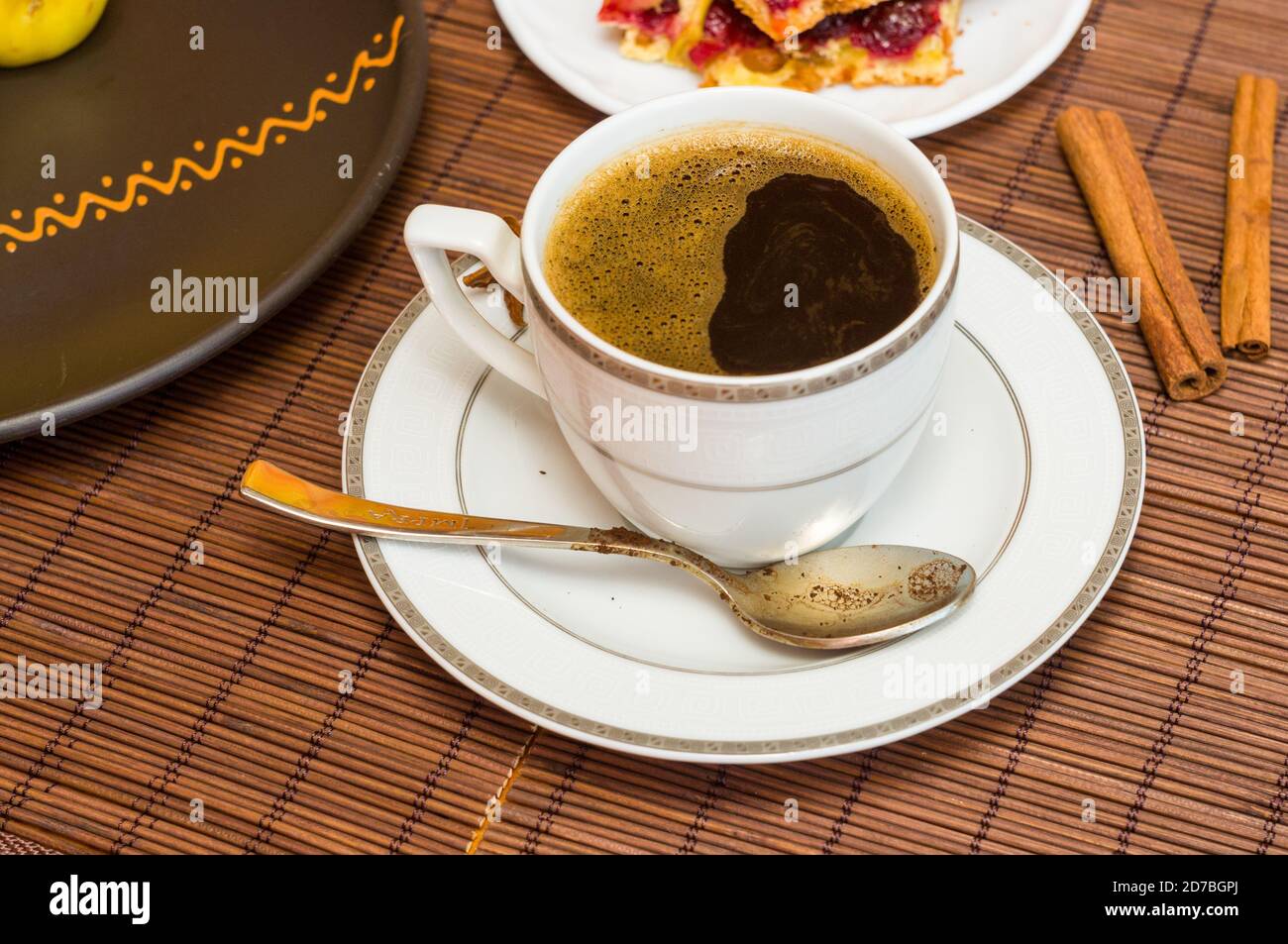 Stillleben - eine heiße Tasse schwarzen Kaffee, hausgemachte Kekse mit Obst auf einer Bambusmatte Stockfoto