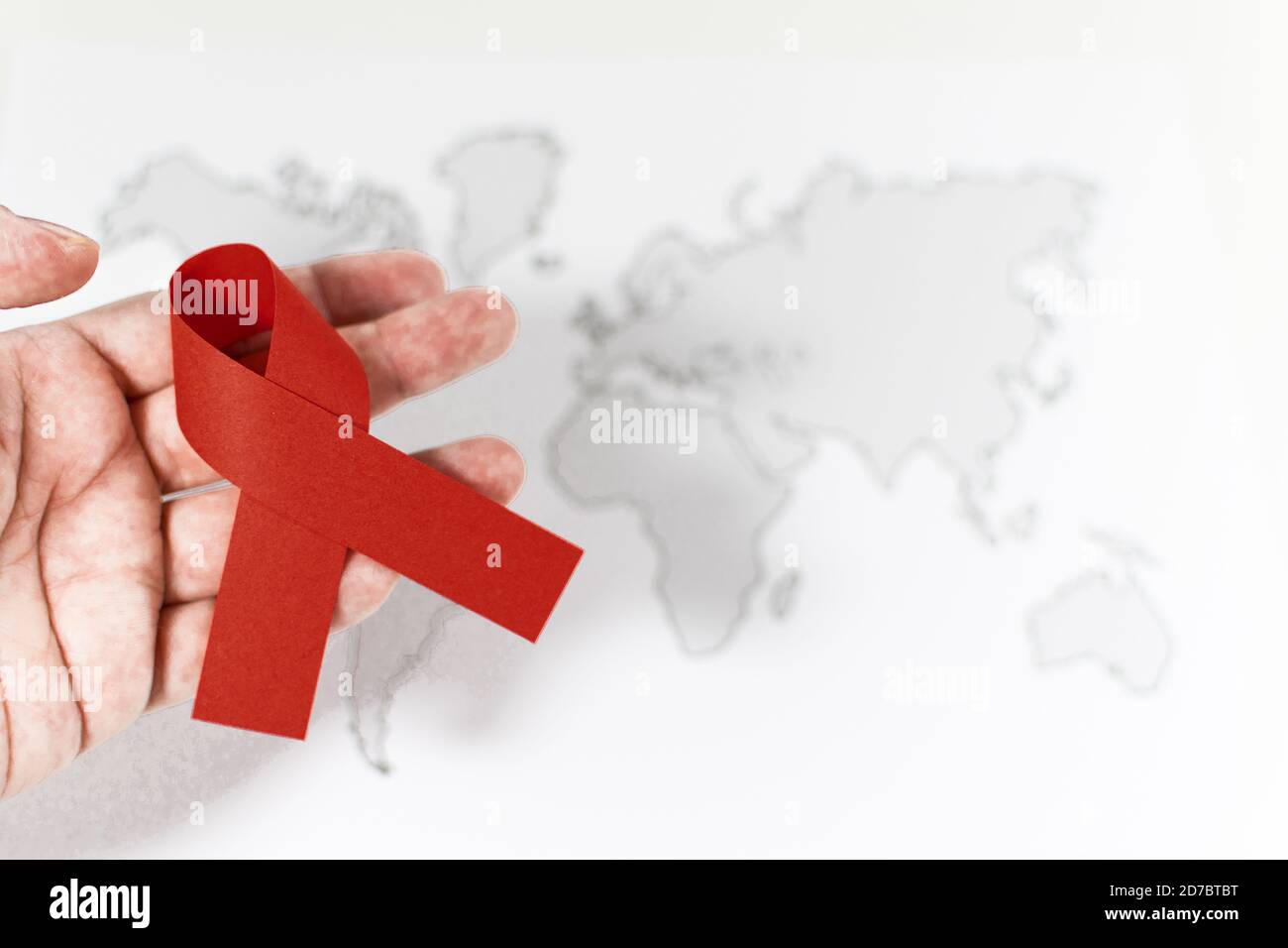 Symbolisches rotes Band auf der Hand der Person - Welten AIDS Tageskonzept Stockfoto