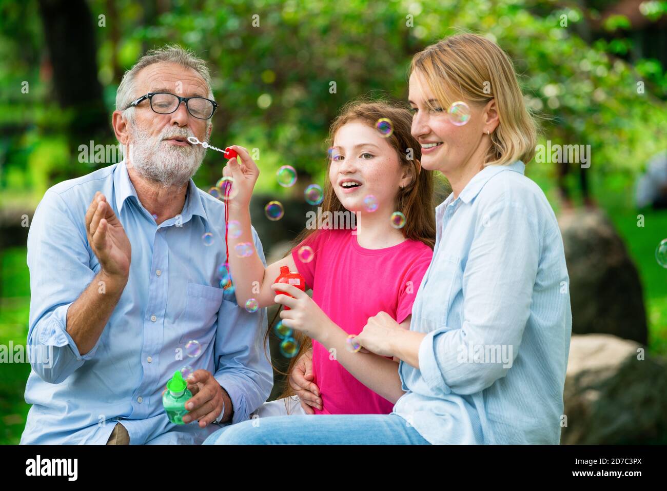 Happy Family bläst Seifenblasen zusammen beim Gehen, Urlaub am Wochenende in den Garten im Sommer. Kid Bildung und Aktivitäten für die ganze Familie. Stockfoto
