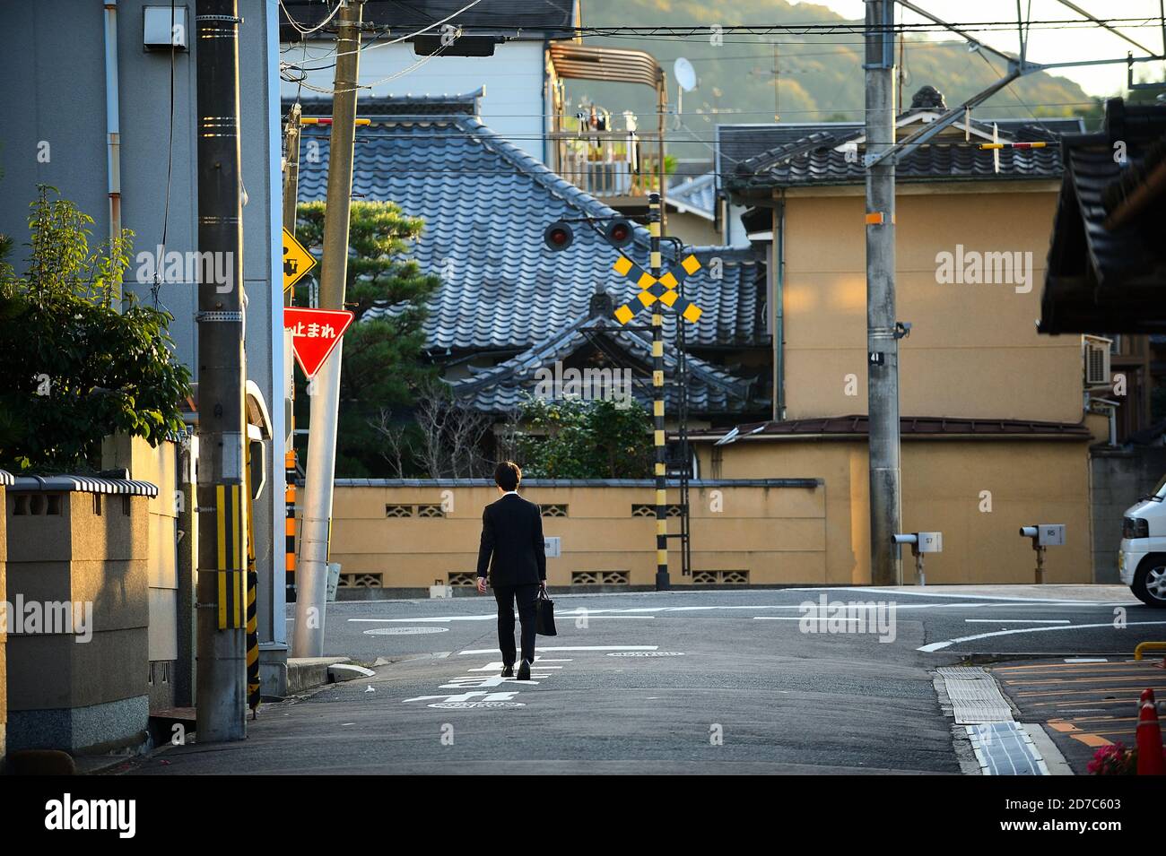 Kyoto / Japan - 2016 Nov 29 : EIN Salaryman in einem schwarzen Anzug trägt eine Tasche, die in der Gasse läuft. Um morgens zur Arbeit zu gehen, schauen Sie zurück. Stockfoto