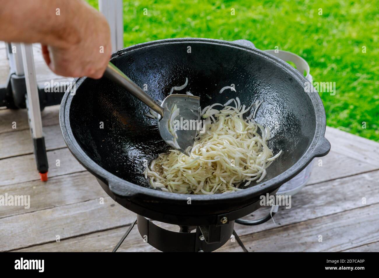 Zwiebel in einem Kessel rösten. Zubereitung leckeres Essen draußen. Stockfoto
