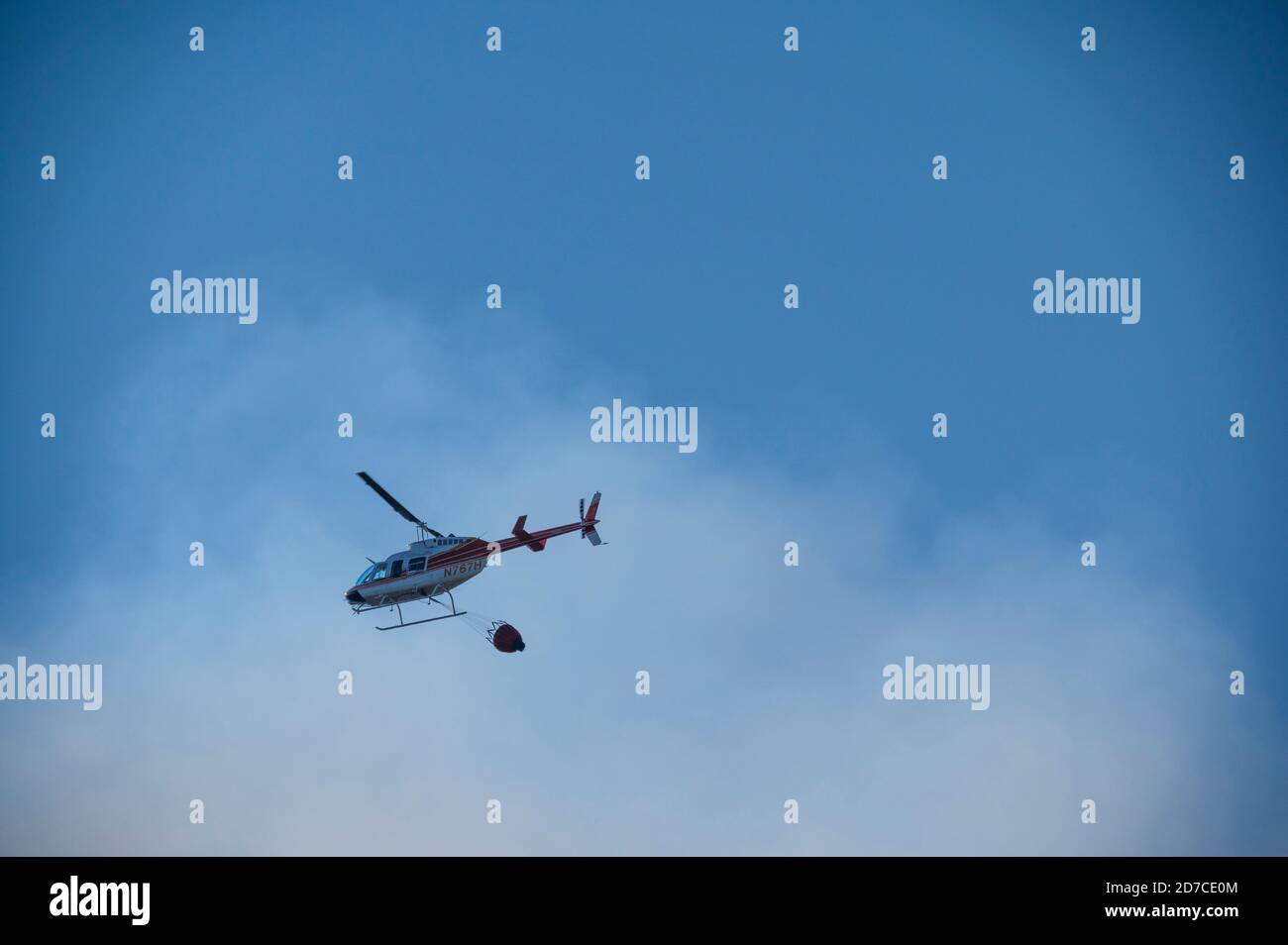 Aerial Brandbekämpfung Hubschrauber mit Feuerwasserbehälter Stockfoto