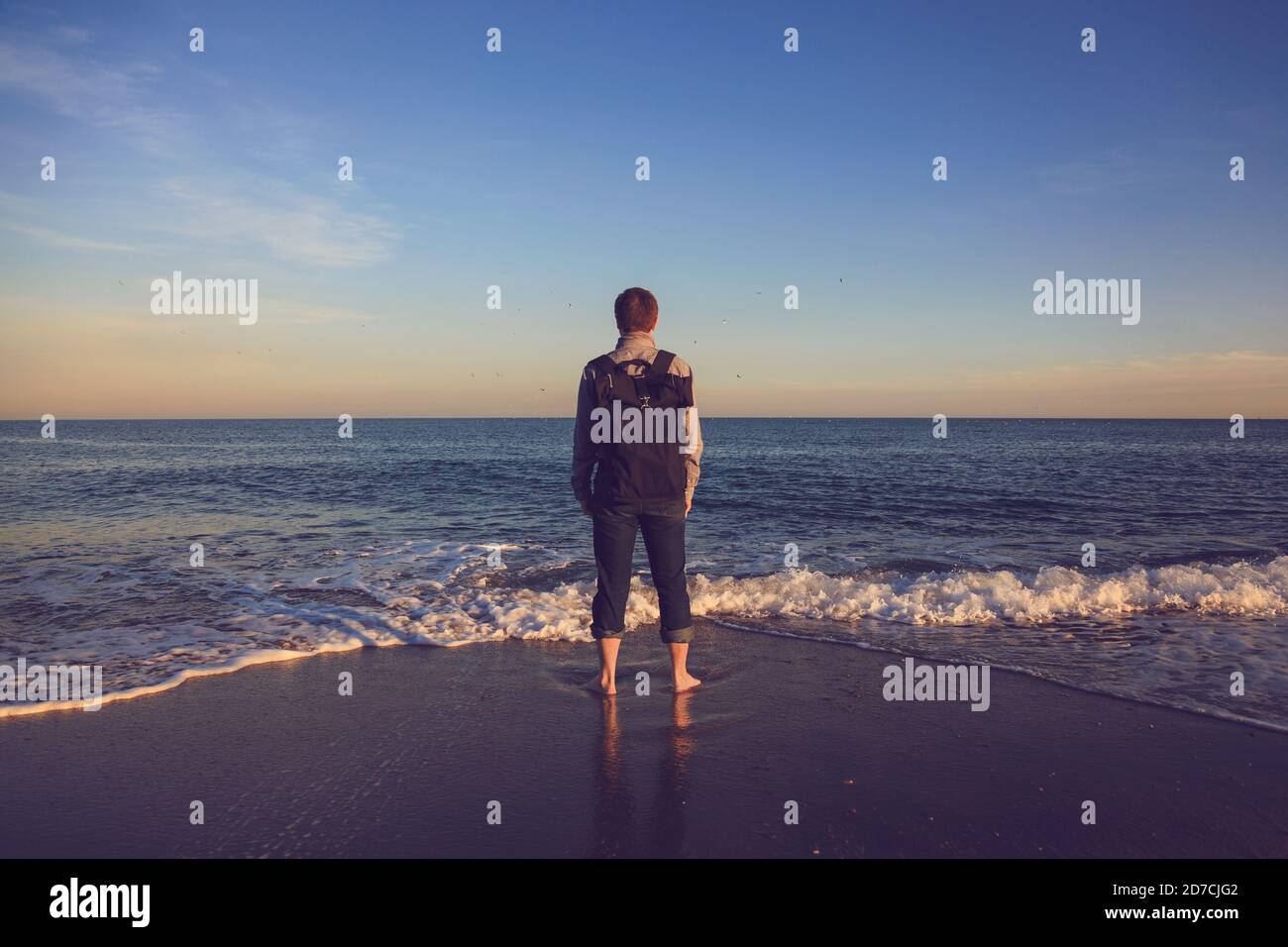 Mann mit Blick auf das Meer. Rückansicht. Instagram-Style Stockfoto