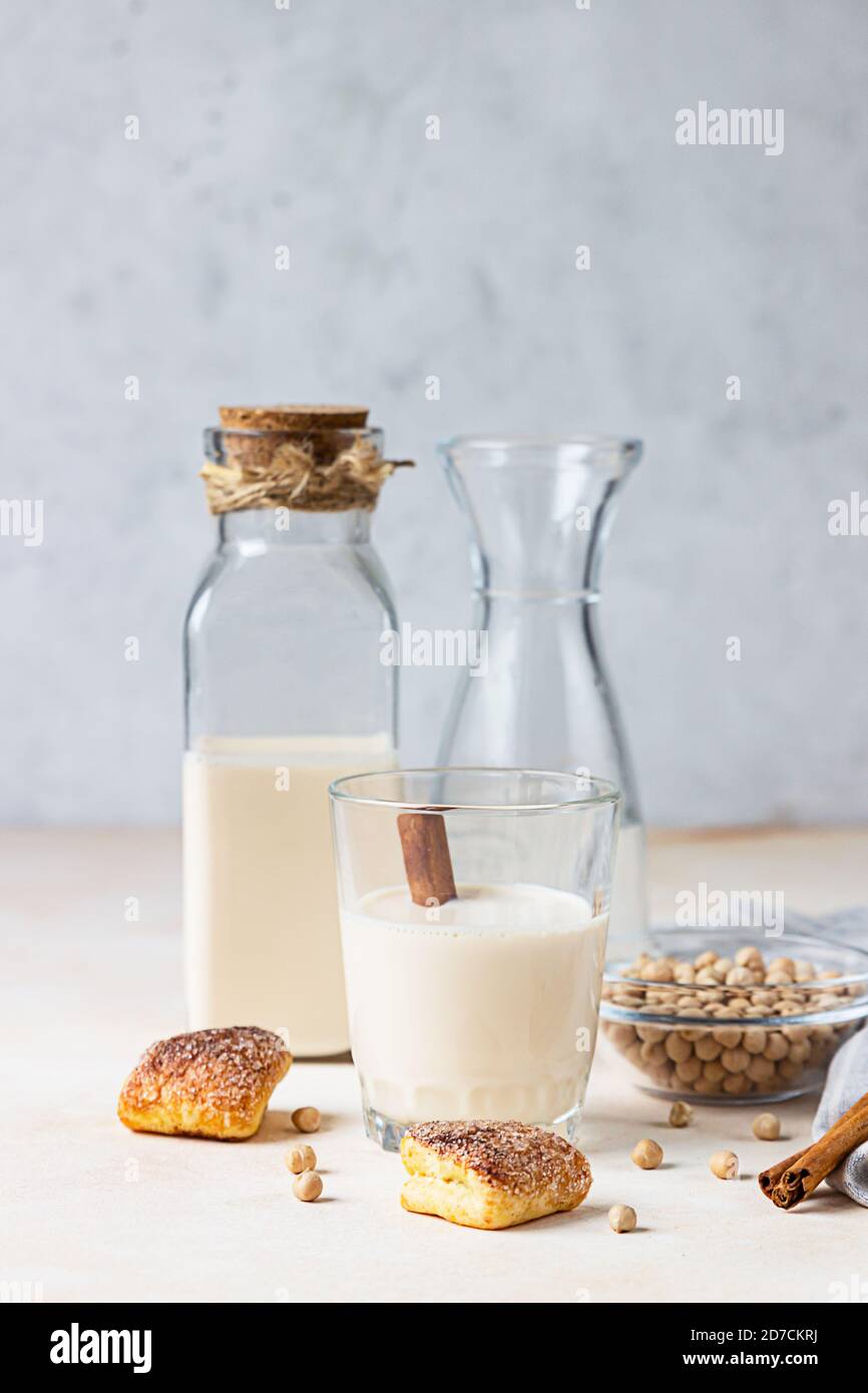Kichererbsen vegetarische Milch in einer Flasche und Glas und rohe Kichererbsen auf hellem Stein Hintergrund. Laktosefreie nicht-Milchprodukte. Gesundes veganes Essen Stockfoto