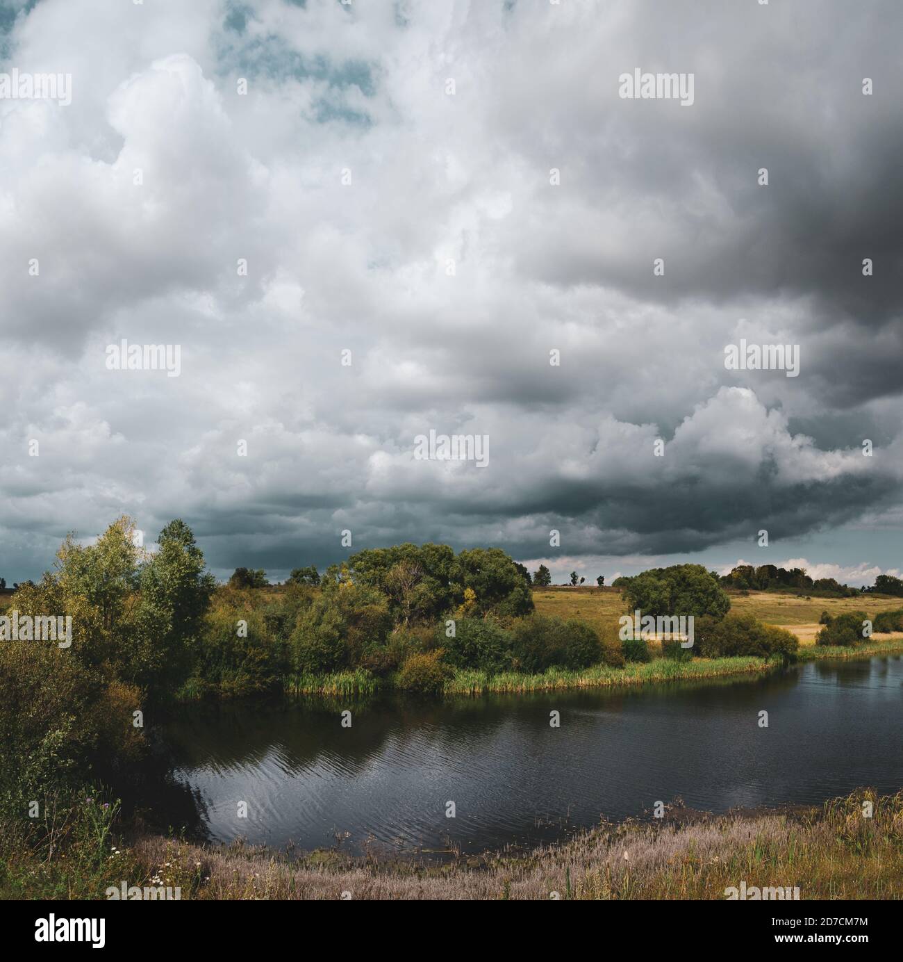 Schöne Aussicht auf den Fluss und dunkle stürmische Wolken über der Land Stockfoto