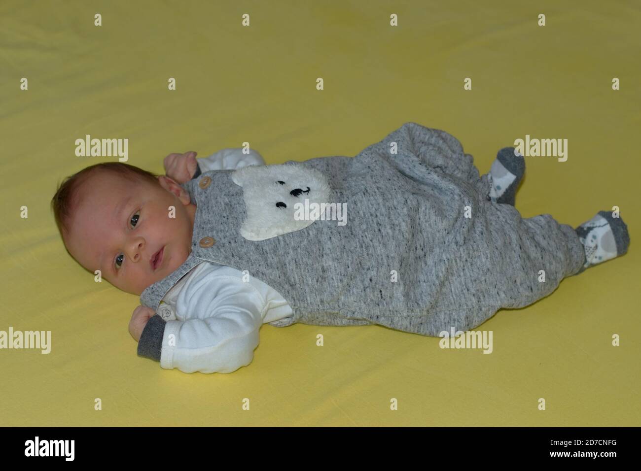 Nahaufnahme von niedlichen Neugeborenen auf gelbem Hintergrund liegen Stockfoto