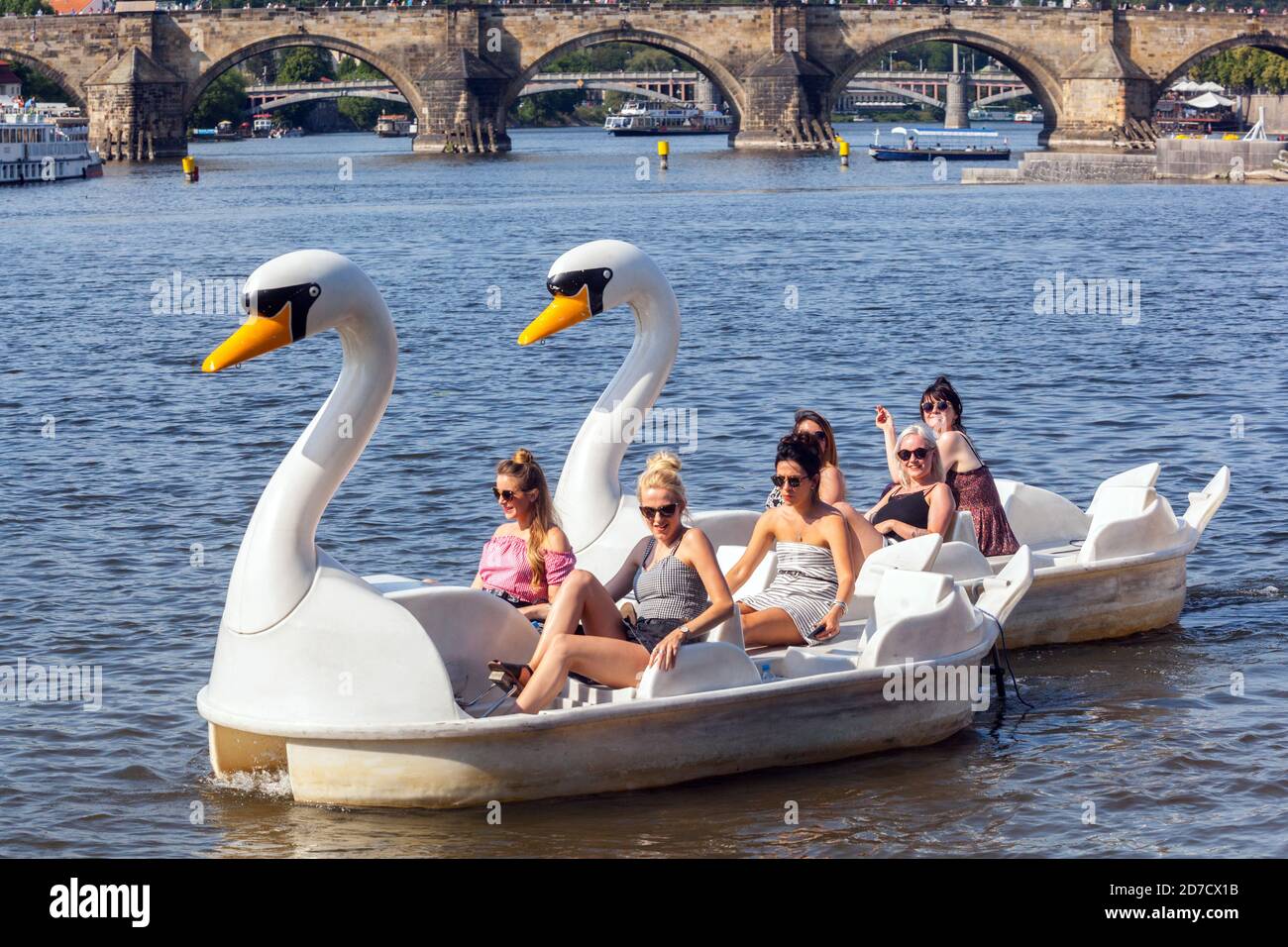 Prag Sommer Tschechische Republik Europa Frauen genießen die Flussfahrt im Schwan Tretboot Moldau in Prag Karlsbrücke zurück Stockfoto