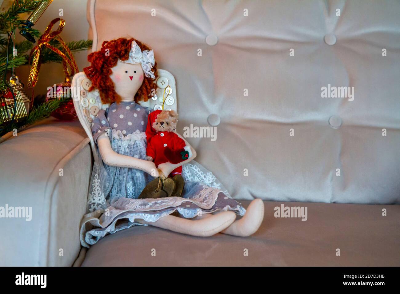 Weihnachtsengel Stoffpuppe mit weihnachtsmann Teddybär, auf weichem Samtsofa, neben dekorierten Baum. Platz für Text kopieren. Ornament Dekoration für den Urlaub Stockfoto