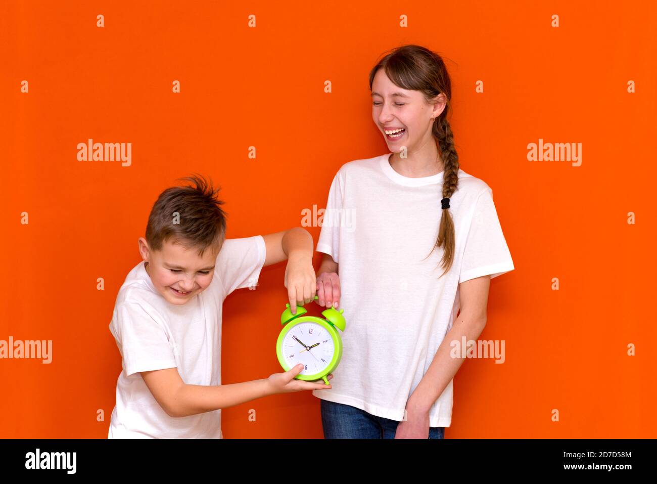 Lachende junge kaukasier zwei Freunde Kerl und Mädchen in weißen leeren leeren Design-T-Shirts posiert auf orangen Studio Wand. Stockfoto