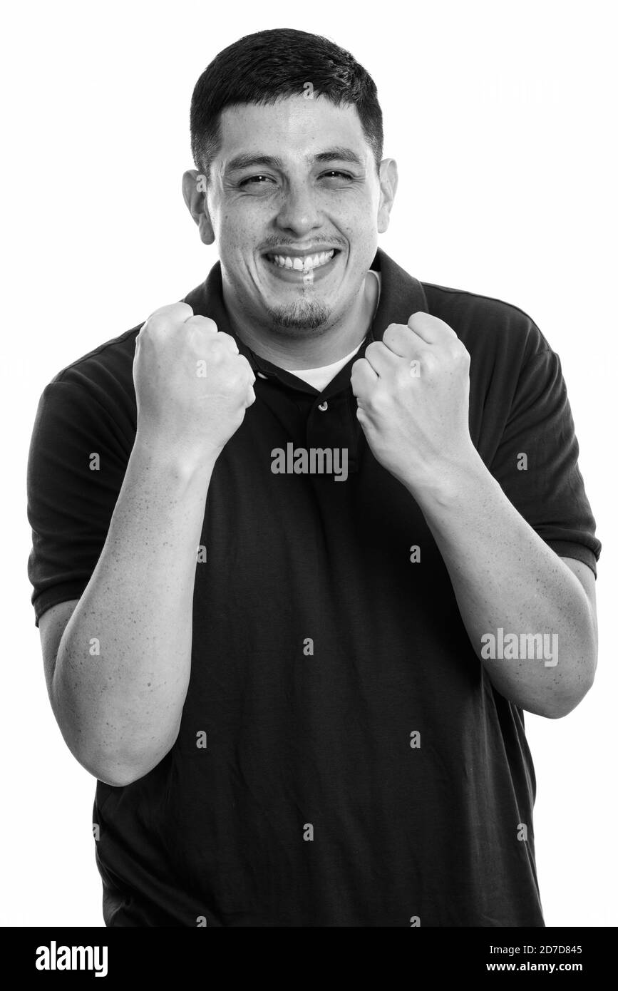 Studio shot der Jungen glücklich Hispanic Mann lächelnd, während sie aufgeregt Stockfoto