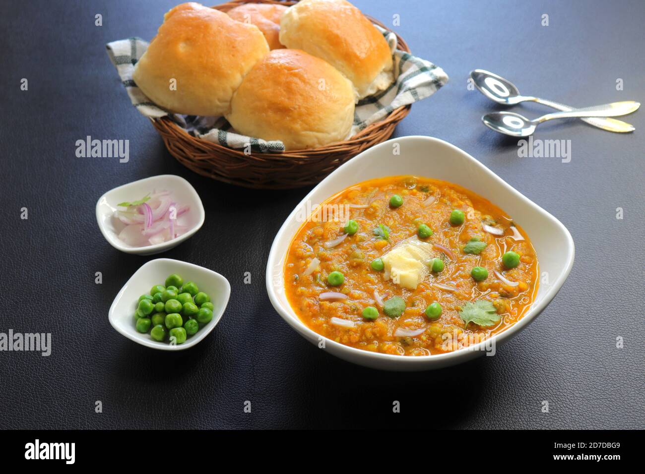 Pav Bhaji im indischen Mumbai Street-Stil, garniert mit Erbsen, rohen Zwiebeln, Koriander und Butter. Würziges dickes Curry aus gemischtem Gemüse. Speicherplatz kopieren. Stockfoto