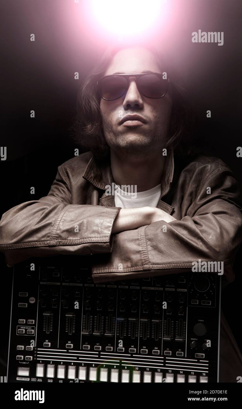 Junger Hip-Hop-Musiker mit Beat-Maschine mit Bühne Lichteffekt Stockfoto