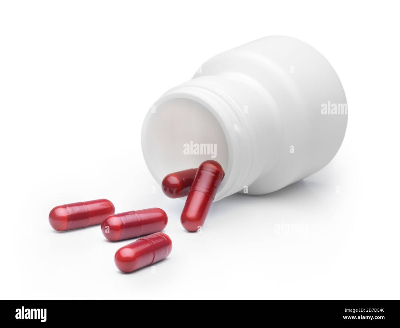 Taumelierte Flasche rote Farbe Pillen verschüttet vor weißem Hintergrund. Medikationskonzept Stockfoto