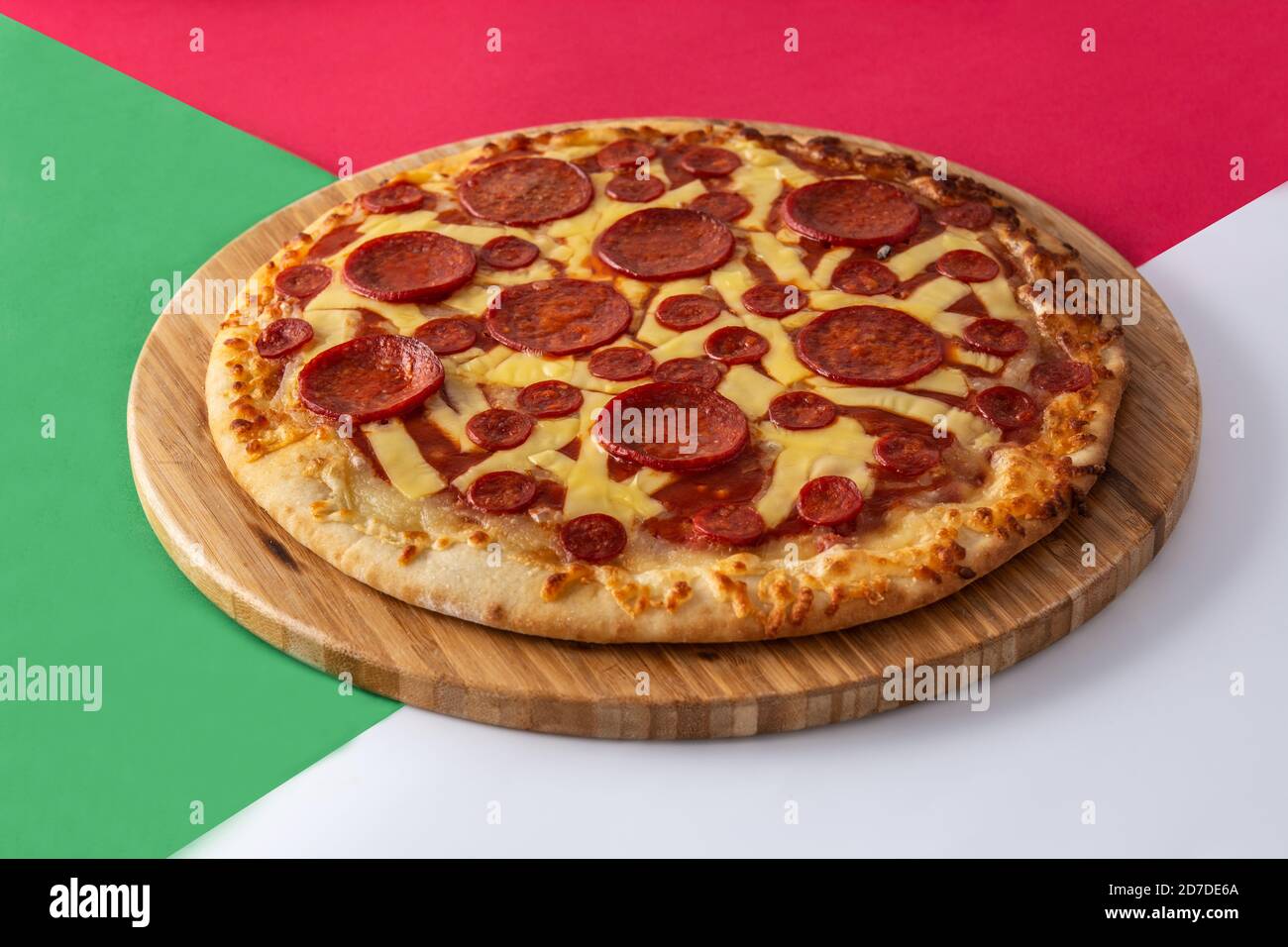 Italienische Pepperoni Pizza auf rot, grün und weiß Stockfoto