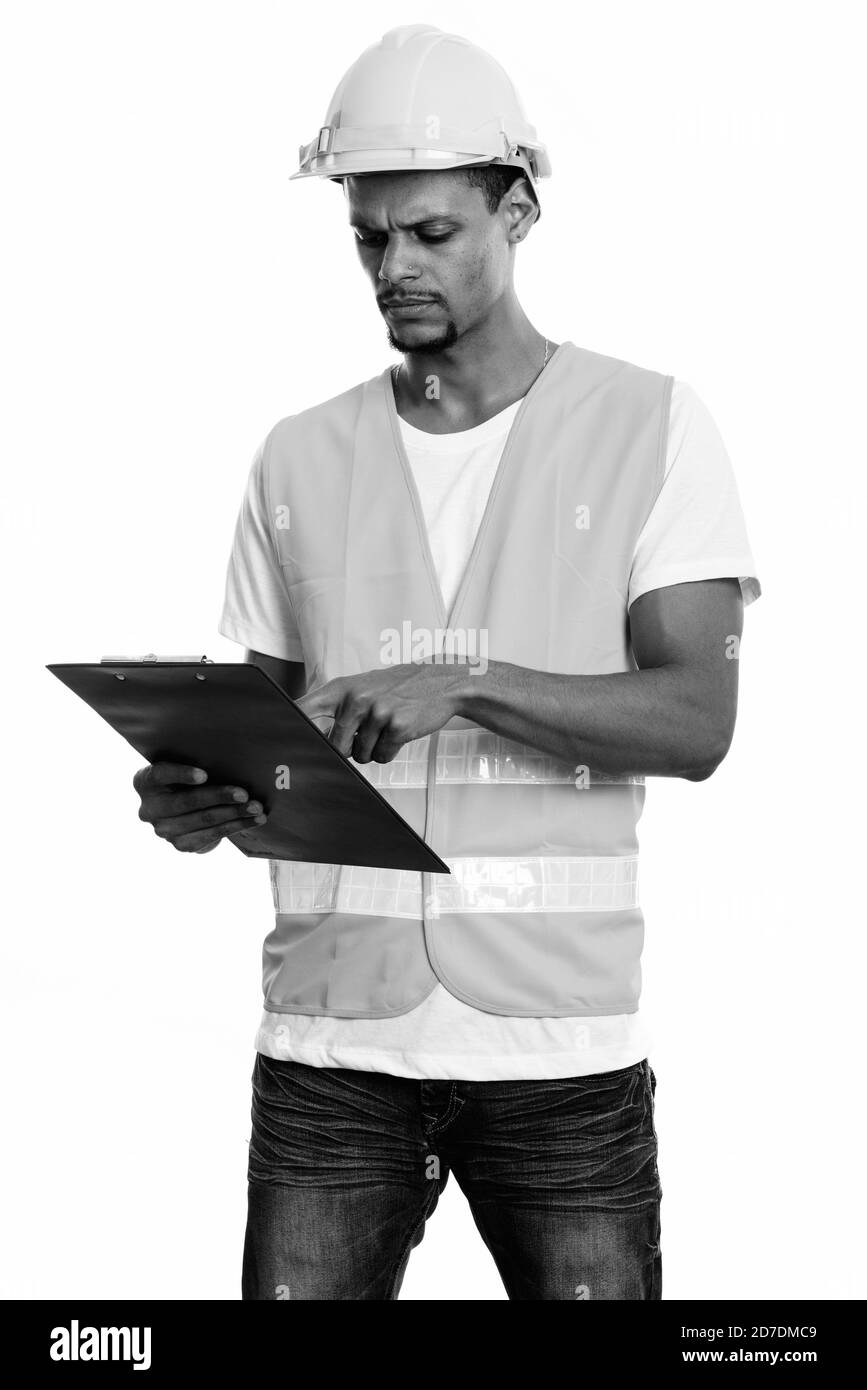 Junge afrikanische Mann Bauarbeiter lesen auf Zwischenablage Stockfoto