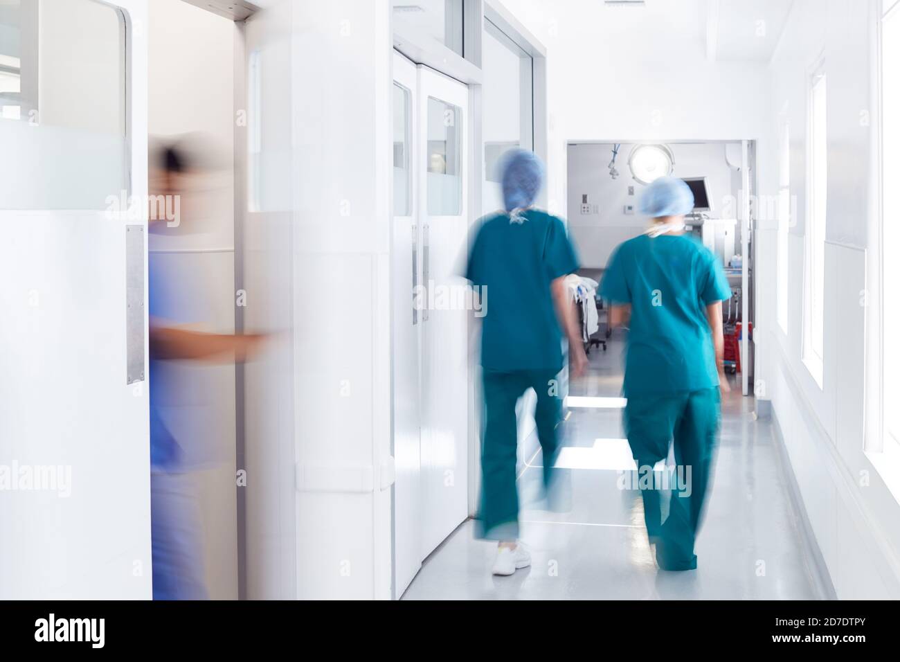 Bewegungsunschärfe Aufnahme Des Medizinischen Personals, Das Scrubs Trägt, In Besetzt Krankenhauskorridor Stockfoto