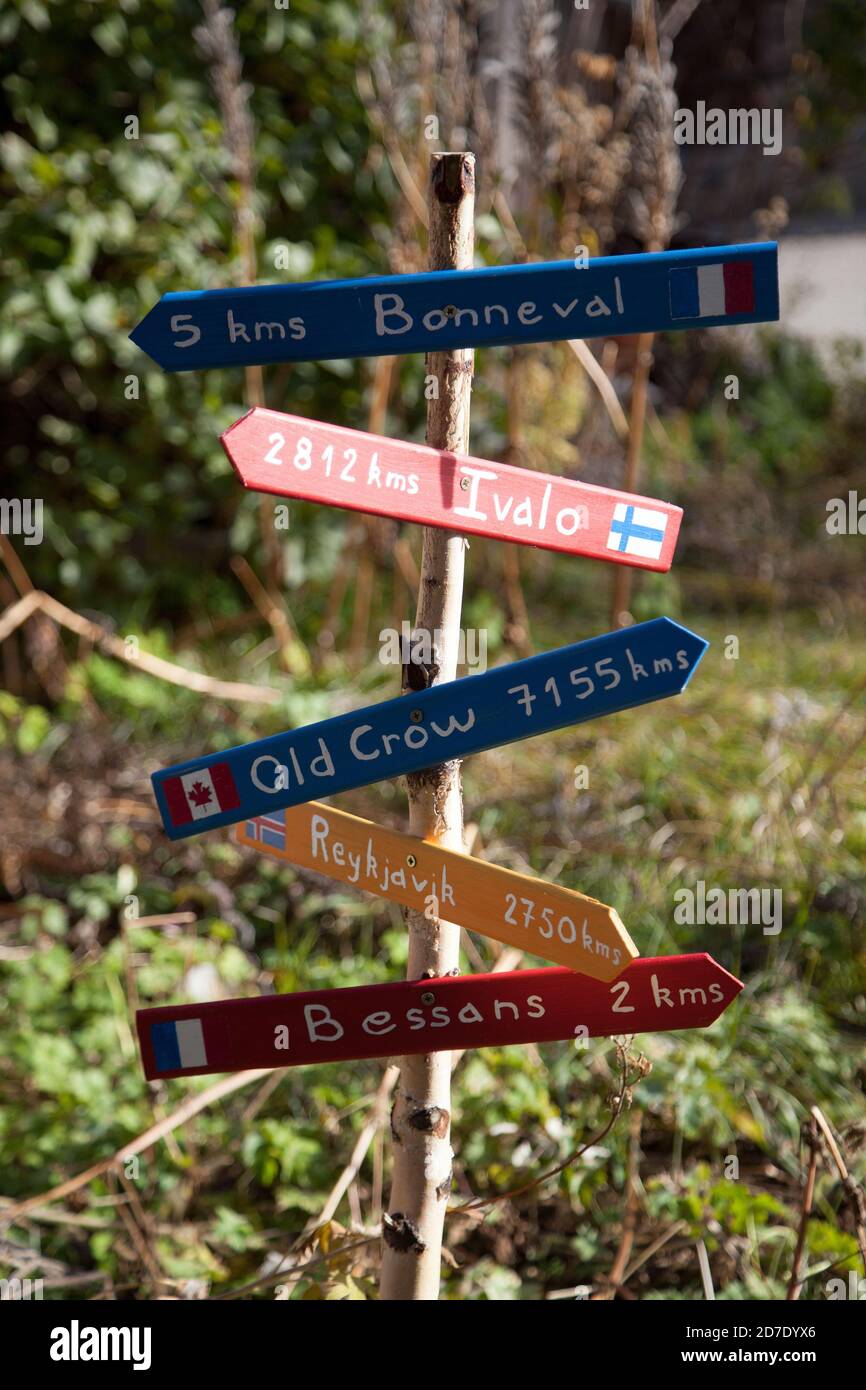5 farbige handgefertigte Schilder auf einem Holzstock in einem Garten des Dorfes Le Villaron in Savoie, die Bonneval, Ivalo, Old Crow, Reykjavik und Bessans anzeigen Stockfoto