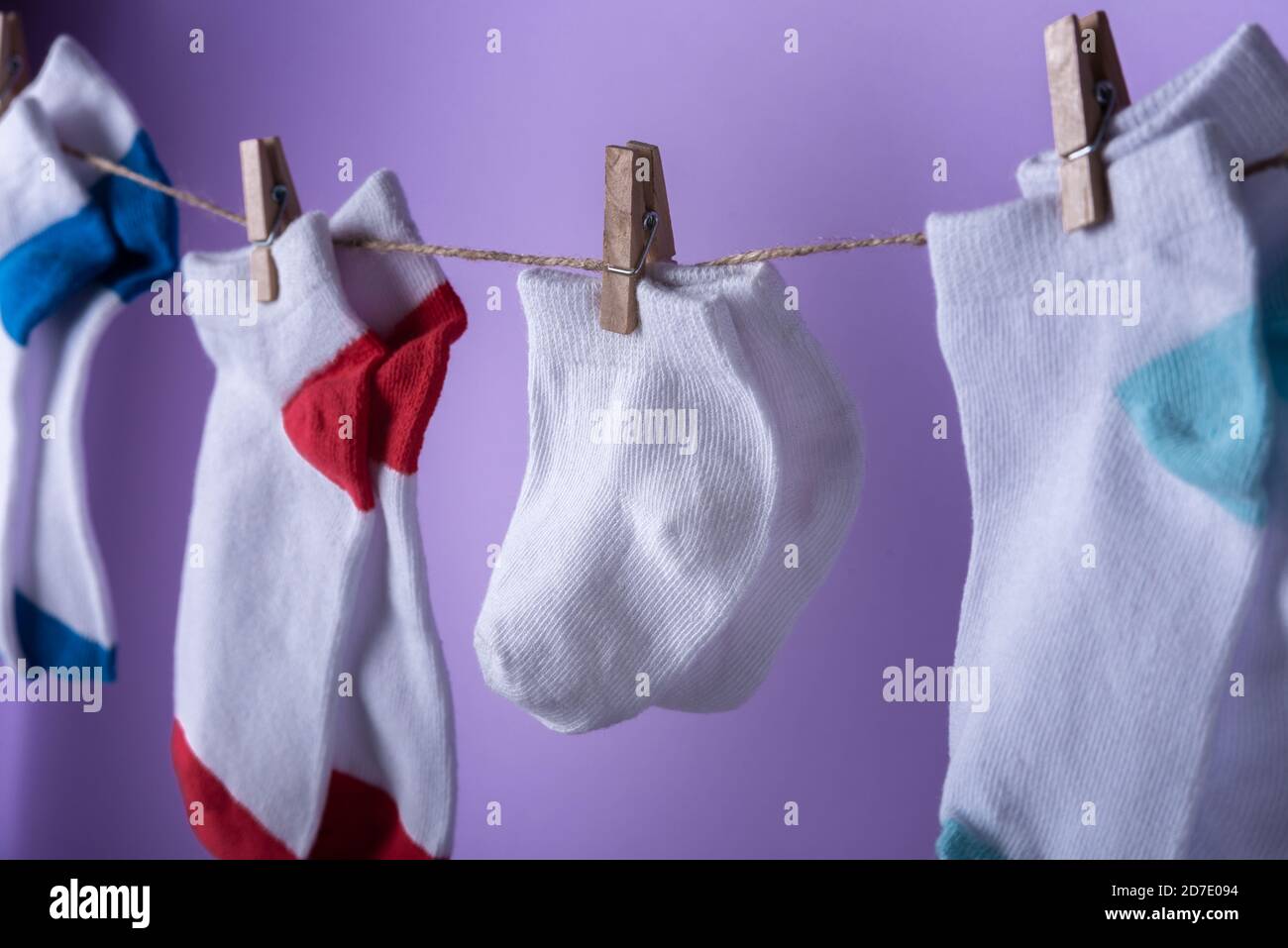 World Preaturity Day Konzept. Normale Größe und winzige Socken am Seil mit violettem Hintergrund Stockfoto