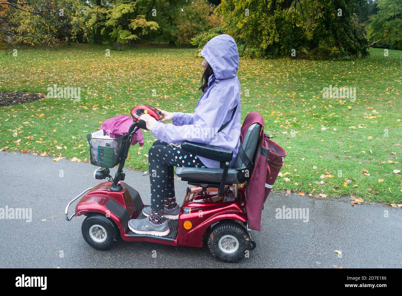 Seitenansicht und Nahaufnahme einer jungen Frau, die einen fährt Mobilitätsroller Stockfoto
