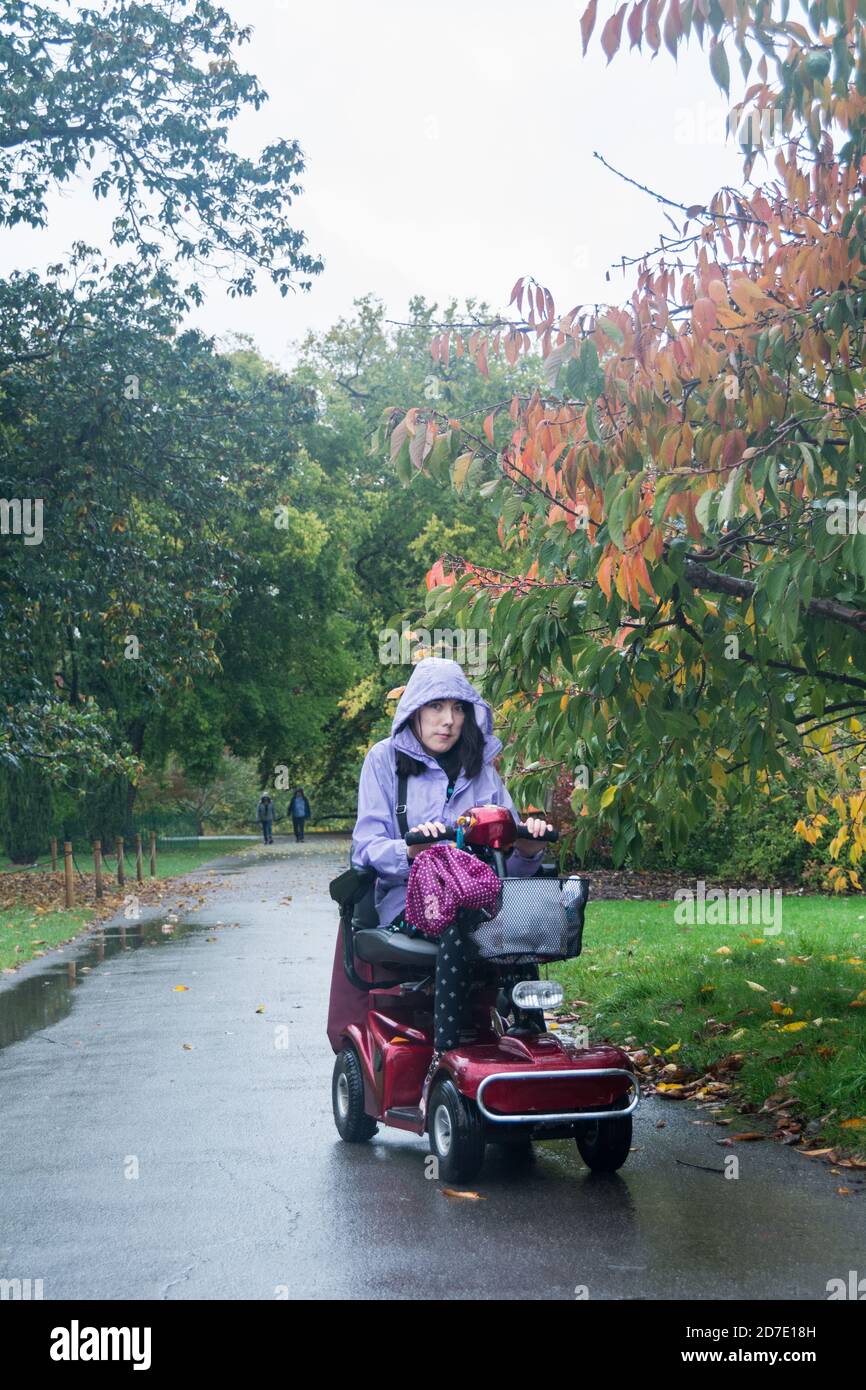 Nahaufnahme einer jungen Frau, die einen Mobilitätsroller fährt Stockfoto