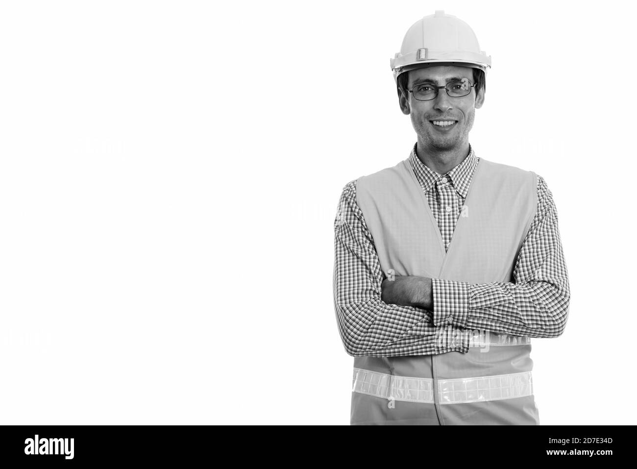 Studio shot Junger glücklicher Mann Bauarbeiter Lächeln beim Tragen von Brillen mit gekreuzten Armen Stockfoto