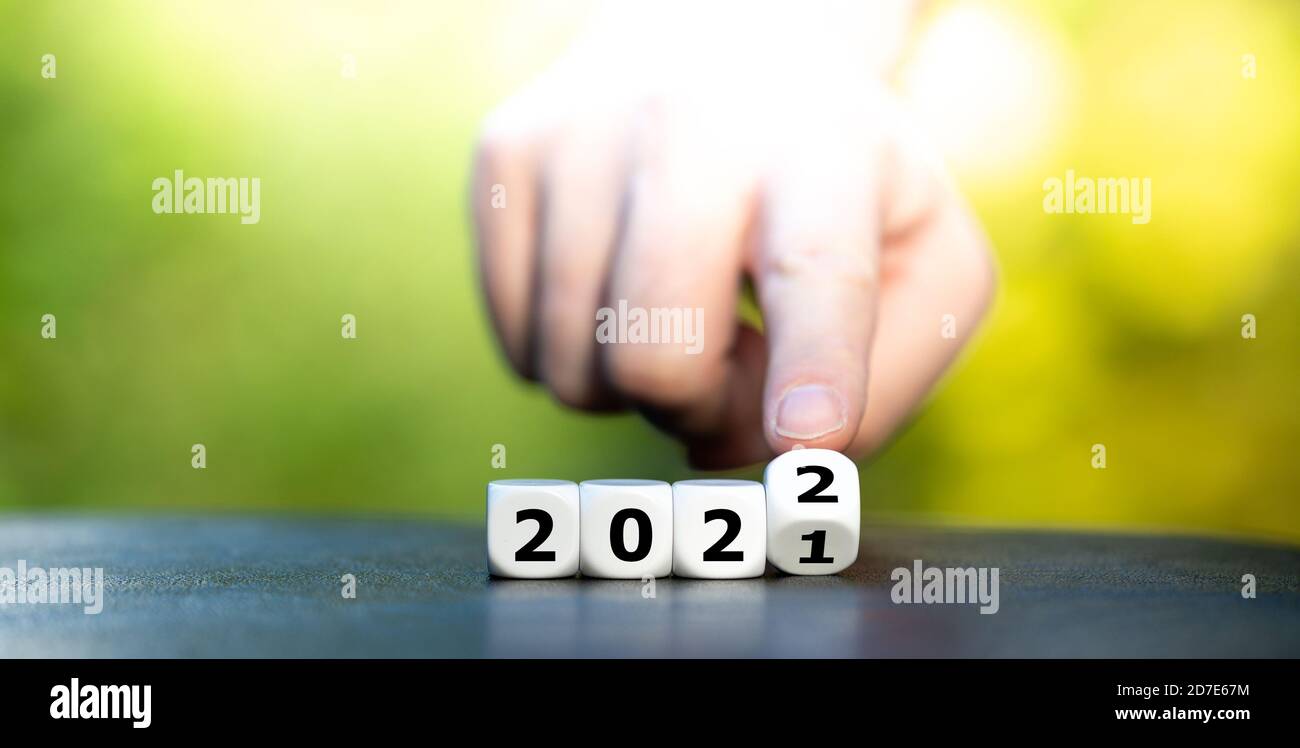 Hand dreht Würfel und ändert das Jahr 2021 auf 2022. Stockfoto