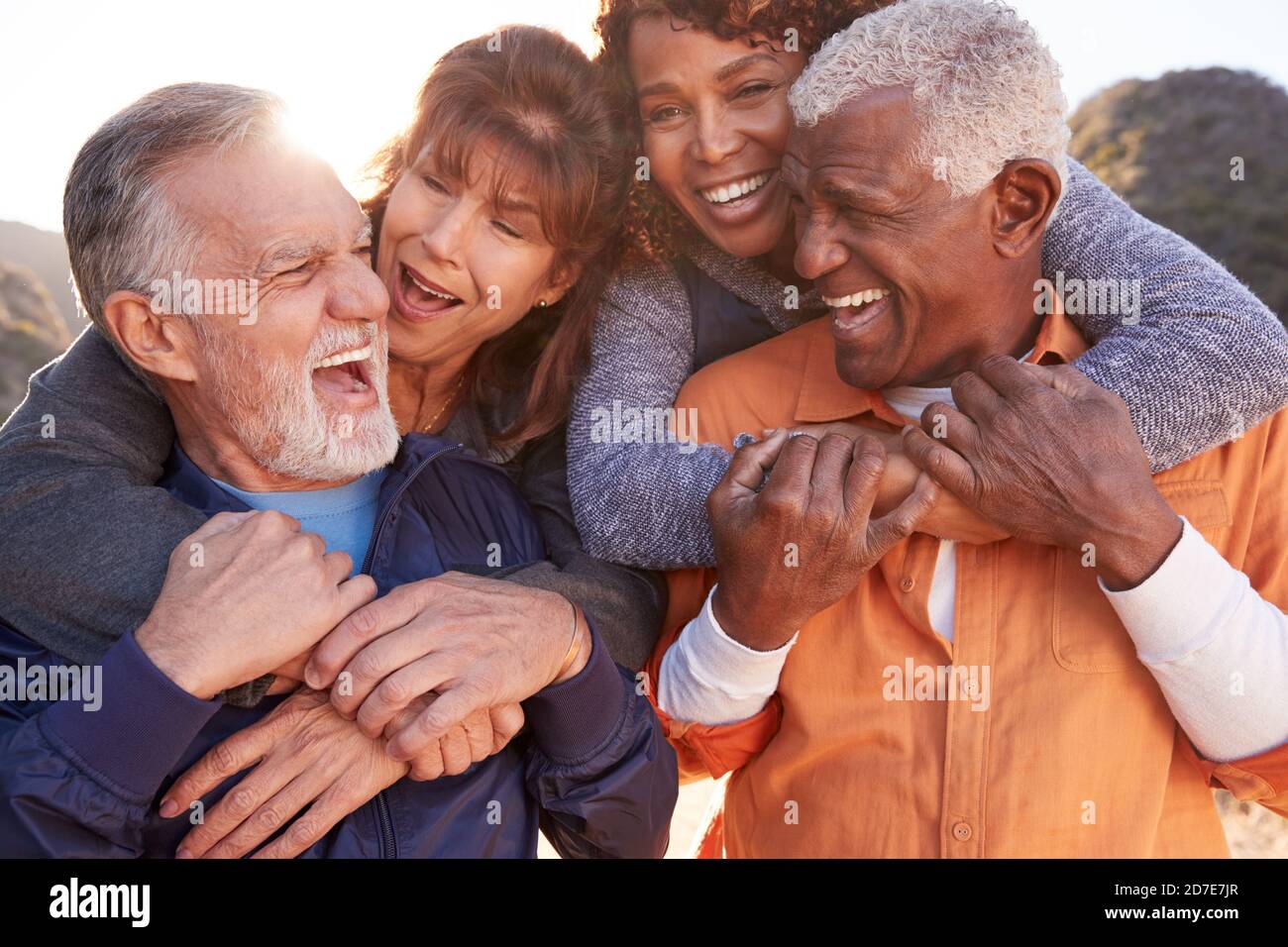 Lächelnde Senior Friends Spaß Haben Gemeinsam Auf Dem Land Spazieren Zu Gehen Stockfoto