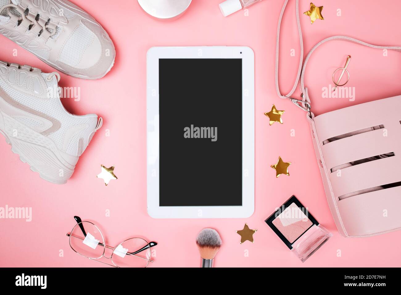 Tablet-Mock-up auf dem rosa Hintergrund mit femininen Accessoires und Make-up-Tools, Draufsicht. Modische, flache Laie Stockfoto