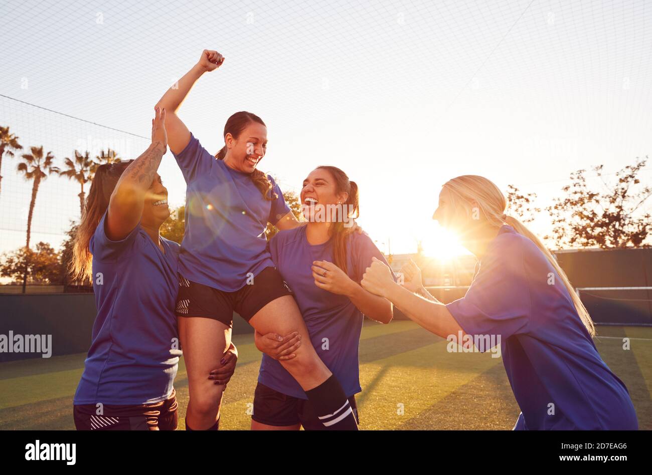 Damen Fußballteam Feiert Das Siegreiche Fußballmatch, Das Spieler Auf Die Straße Hebt Schultern Stockfoto