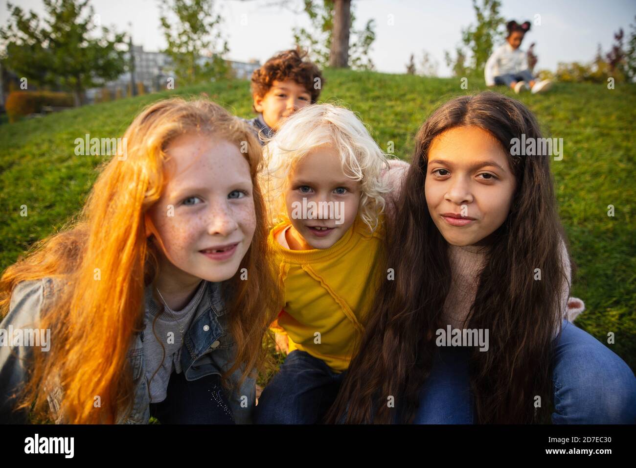 Einheit. Interracial Gruppe von Kindern, Mädchen und Jungen spielen zusammen im Park im Sommer Tag. Freundschaft hat keine Rasse. Glück, Kindheit, Bildung, Diversity-Konzept. Schauen Sie glücklich und aufrichtig. Stockfoto