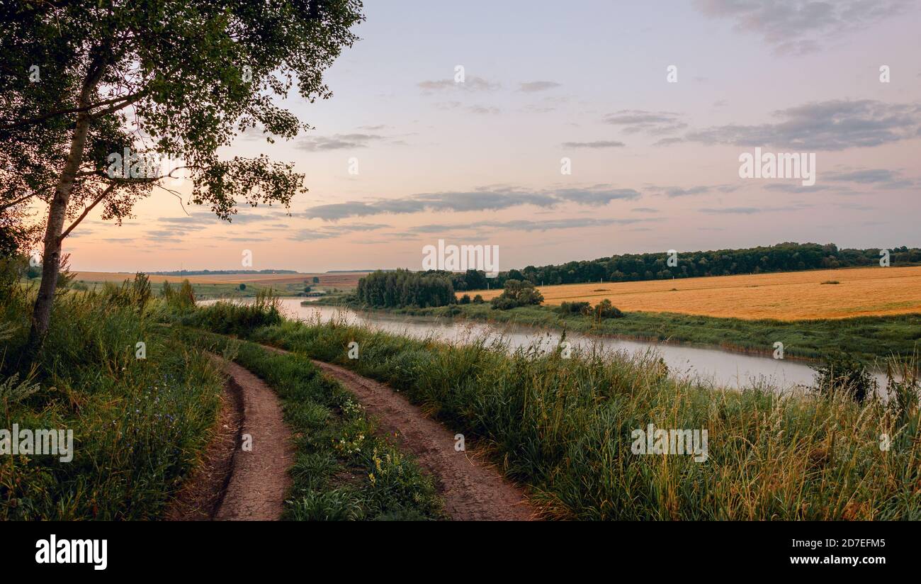 Ruhige ländliche Landschaft mit Landstraße und Feldern bei Sonnenaufgang Stockfoto