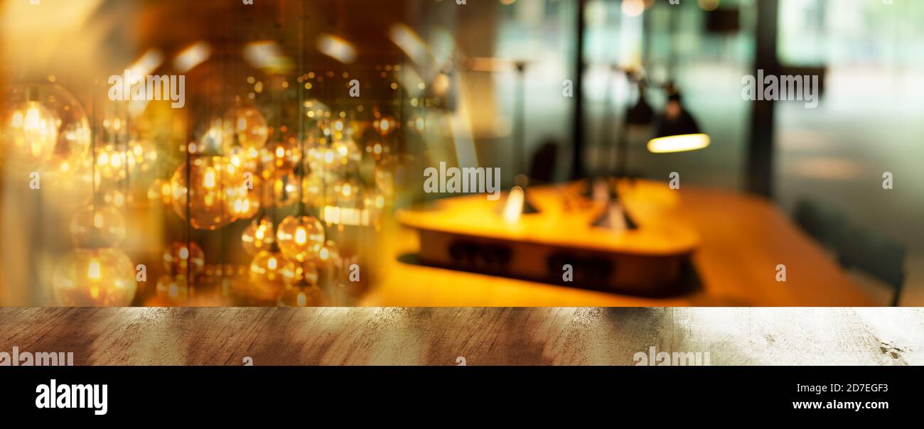Platte aus braunem Holz Tisch mit Blur Licht Lampe Party In Bar oder Pub Banner Hintergrund Stockfoto