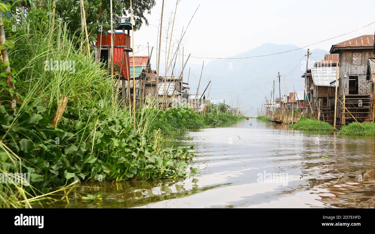 Dorf am See Inle, Myanmar. Großer Kanal zwischen Häusern auf Stelzen gebaut. Auf dem Inle-See leben eine große Gemeinschaft von Fischern und Bauern. Stockfoto