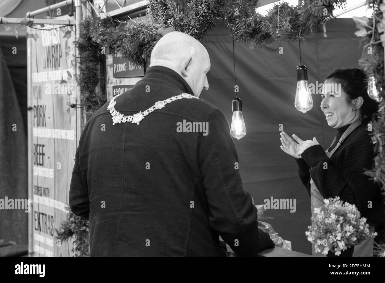 Stallholder spricht mit dem Bürgermeister von Harrogate, Stuart Martin, auf einem Weihnachtsmarkt in Harrogate, North Yorkshire, England, Großbritannien. Stockfoto