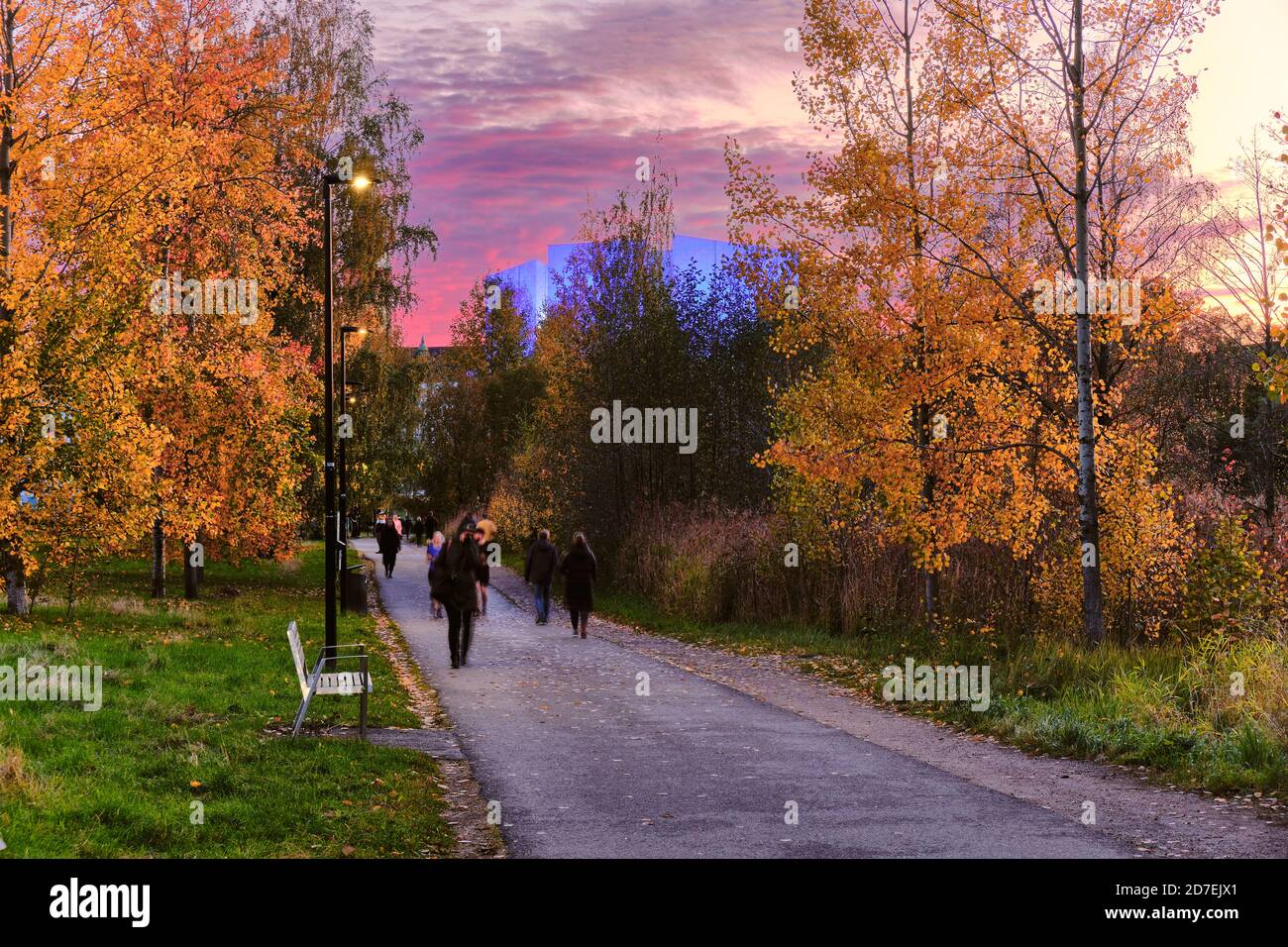 Fussgängerweg im Kluuvi Zentralbezirk von Helsinki im Herbst. Schöner Sonnenuntergang und blaues Licht für Helsinki Hall im Hintergrund, Finnland. Stockfoto