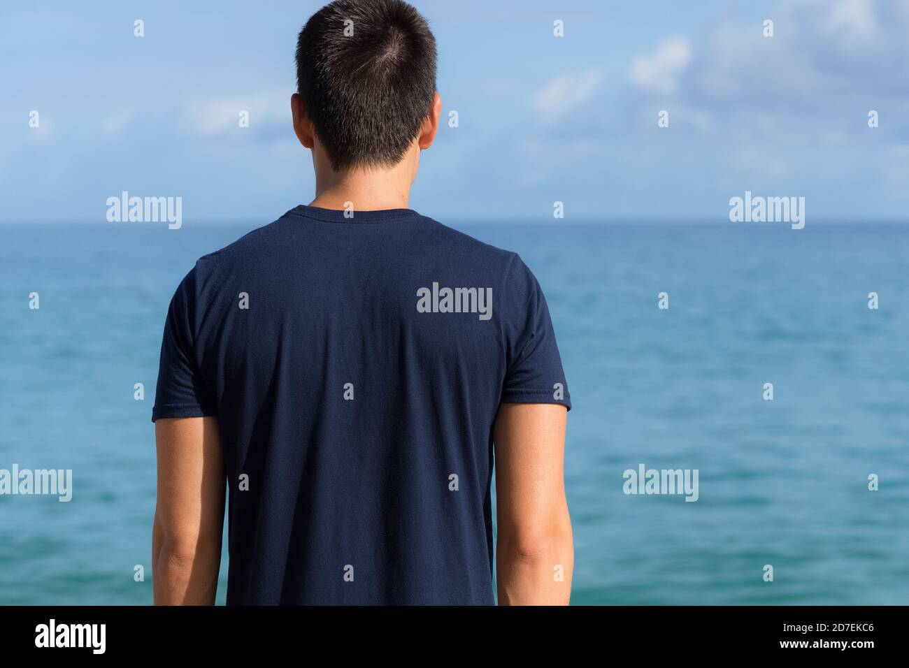 Denkender junger Mann, der zum Meereshorizont blickt. Freiheit und Kontemplation. Stockfoto