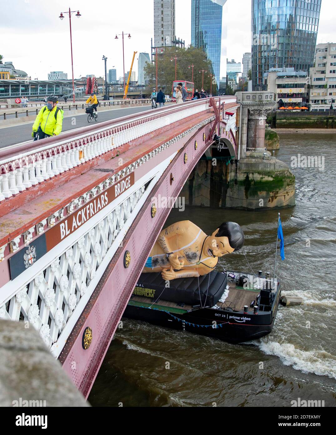 Bild zeigt: Borat Schlauchboot geht die Themse in London hinunter, um Borat  zu fördern 2 maskierte Radfahrer überqueren Blackfriars, wie das  Schlauchboot unter geht Stockfotografie - Alamy
