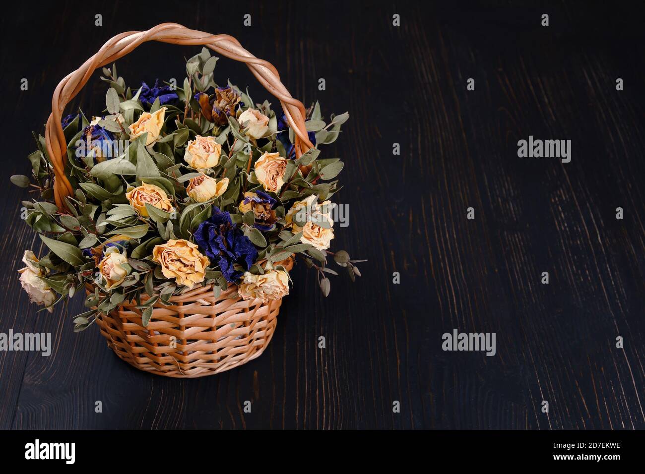 Vintage-Korb mit trockenen toten Blumen auf schwarzem Hintergrund, kopieren Raum Stockfoto