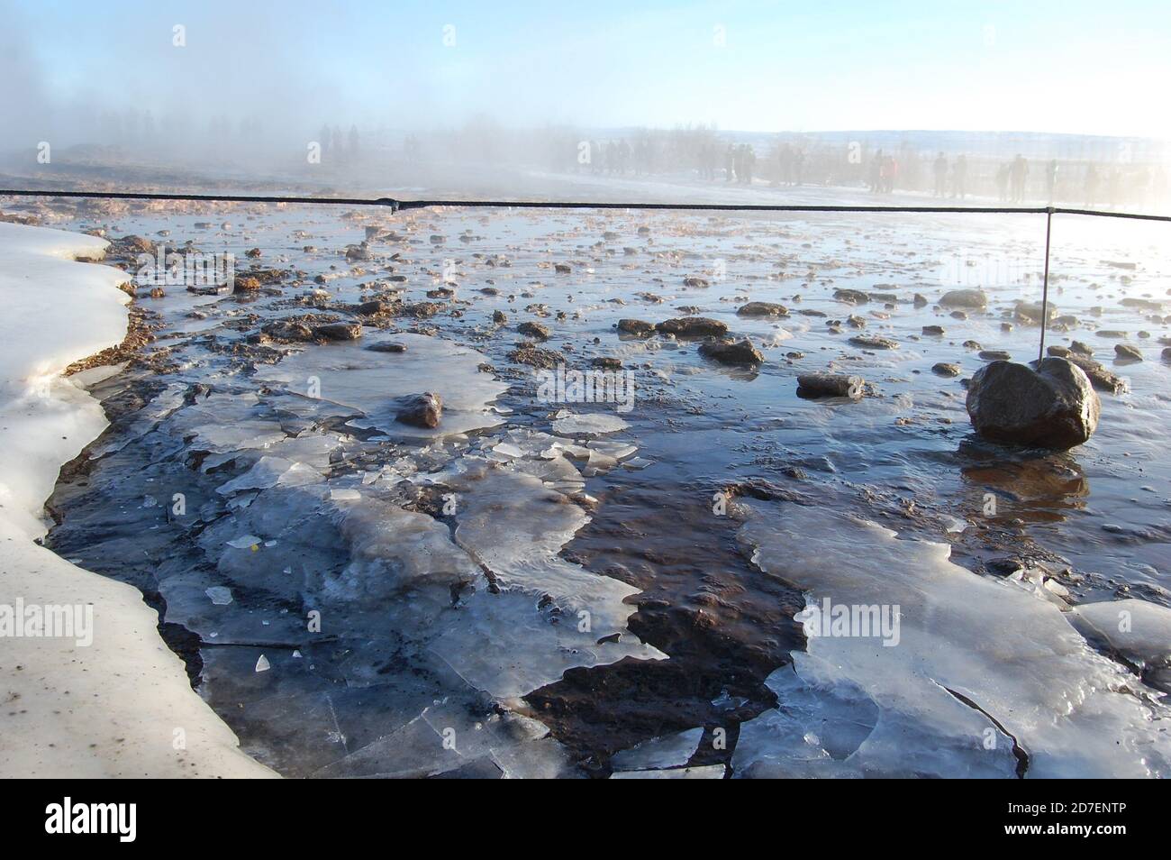 Strokkur Geothermie Gebiet im Winter mit Eis auf dem Heißes Wasser Poll und Leute um warten auf den Geysir Sprühen Stockfoto