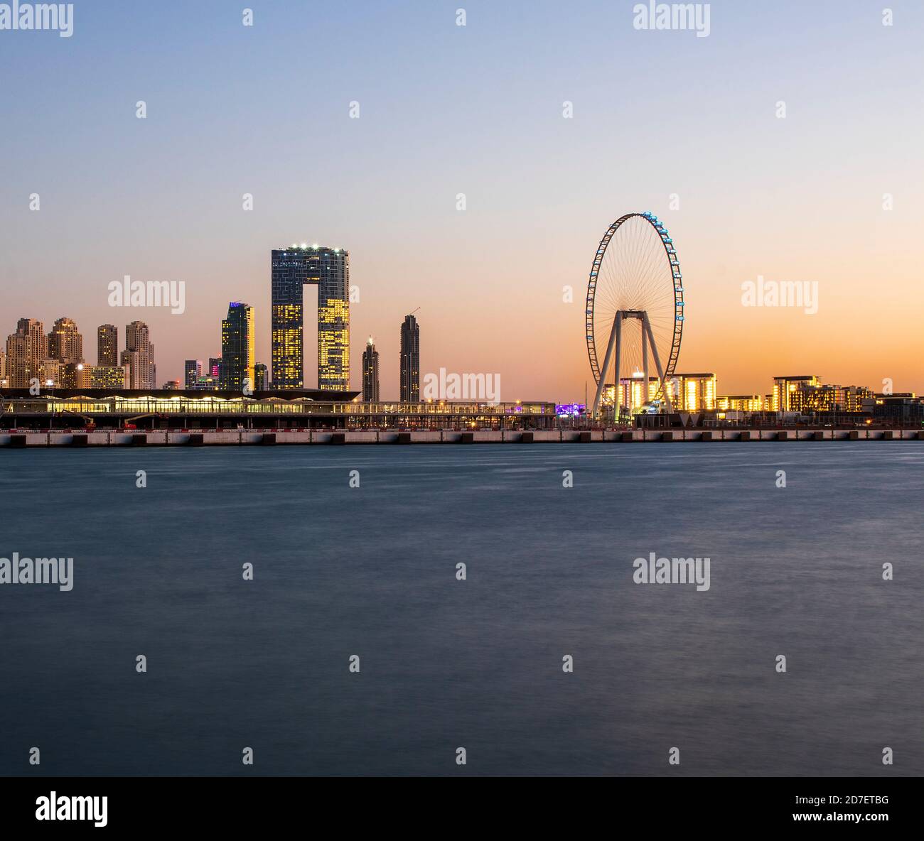 Blick auf DIE Jumeirah Beach Residence und das blaue Wasser nach Sonnenuntergang. Aufgenommen aus Palm Jumeirah, einer künstlichen Insel. Das höchste Riesenrad, Ain Dubai Can als Stockfoto
