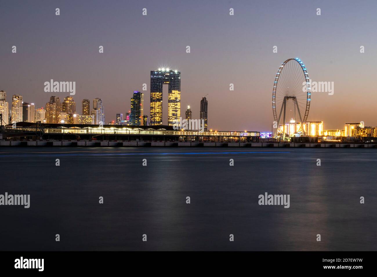 Blick auf EINE Jumeirah Beach Residence und Blue Waters nach Sonnenuntergang. Aufgenommen aus Palm Jumeirah, einer künstlichen Insel. Das höchste Riesenrad, Ain Dubai Stockfoto