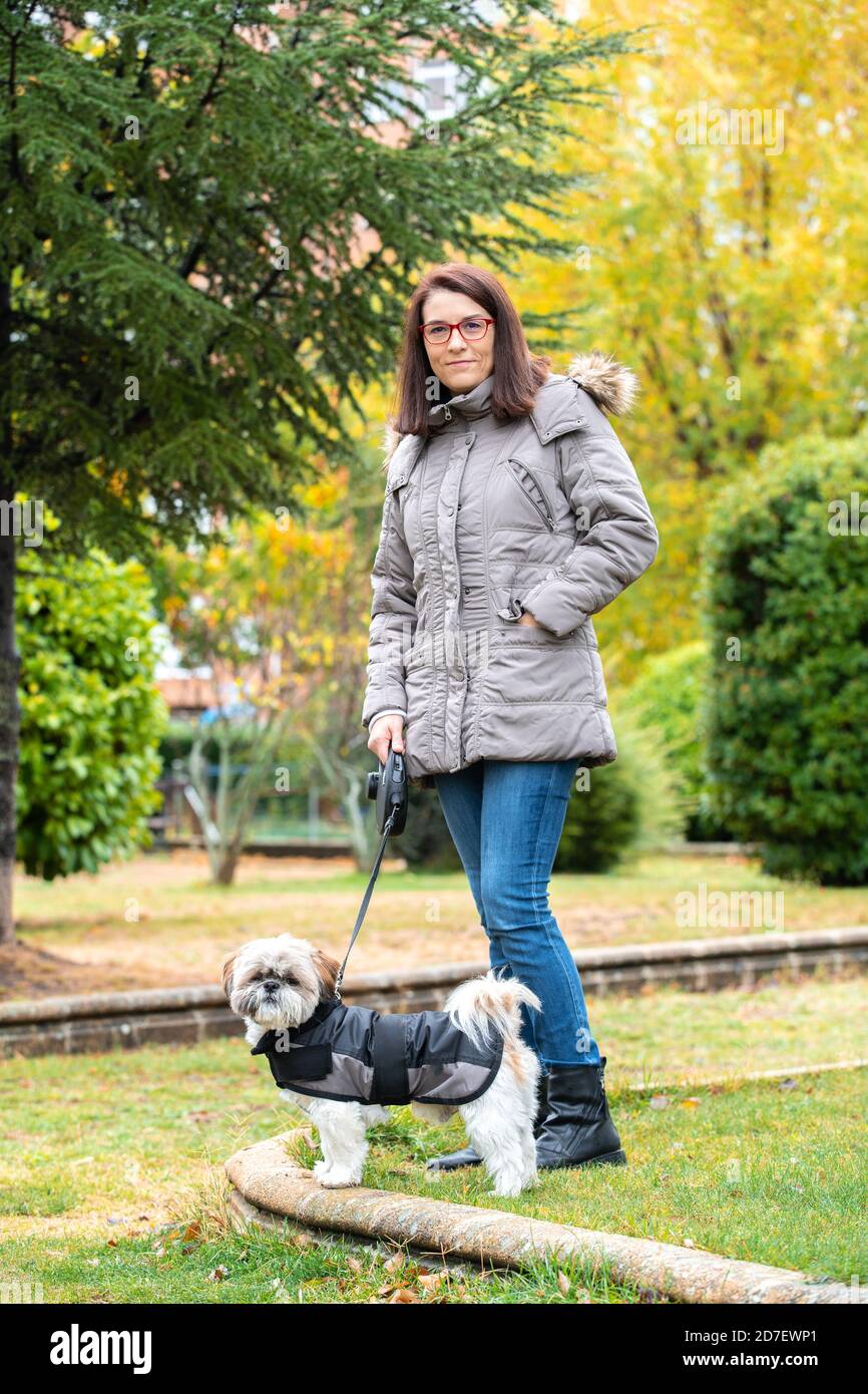 Frau, die im Park mit ihrem Hund in der Regen Stockfoto