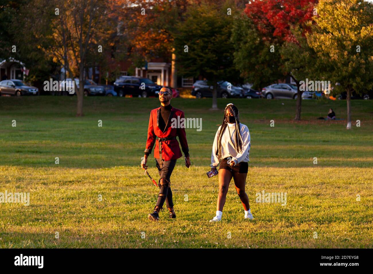 Frederick, MD, USA 10/14/2020: Ein junges afroamerikanisches Paar in modischer Kleidung läuft an einem sonnigen Herbstnachmittag gemeinsam in einem Park. Stockfoto