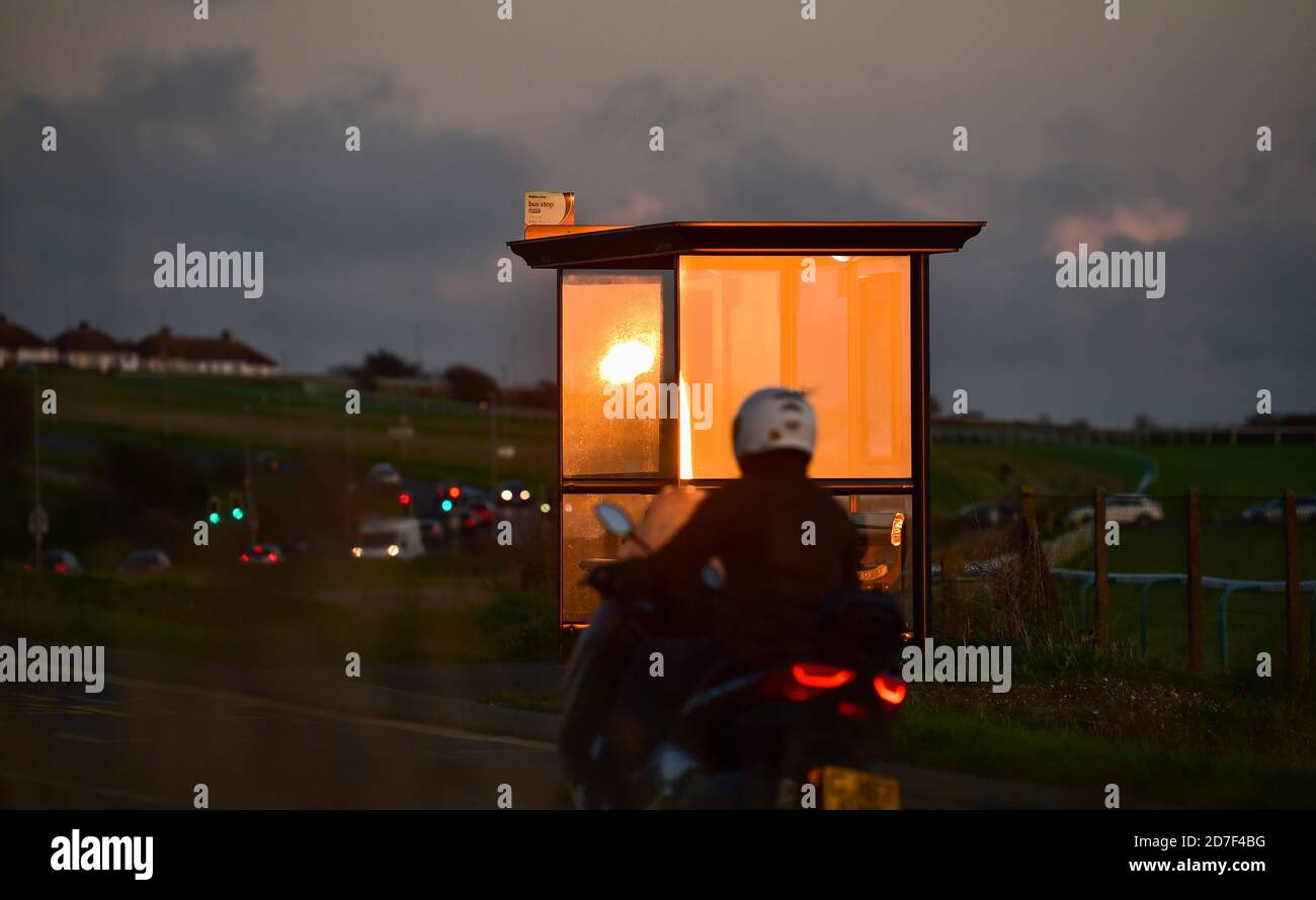 Brighton UK 22. Oktober 2020 - die untergehende Sonne spiegelt sich in einer Bushaltestelle von Brighton Racecourse im Osten der Stadt als unruhigen Wetter wird prognostiziert, dass in ganz Großbritannien in den nächsten Tagen zu verbreiten : Credit Simon Dack / Alamy Live News Stockfoto