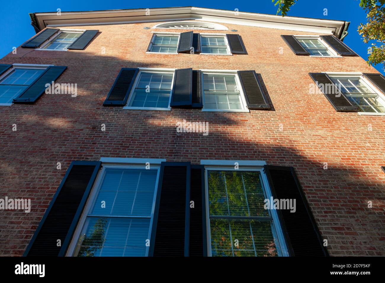 Frederick, MD, USA: 10/13/2020: Ein Backsteinhaus in der Innenstadt von Frederick mit hohen Fenstern und schwarzen Fensterläden. Das Wohngebäude Stockfoto