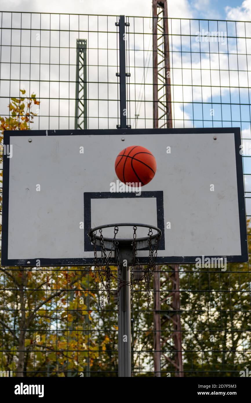 Basketball-Action mit einem fliegenden Ball aus dem Training und Üben Sie zu werfen und schlagen Sie den Basketball in den Basketball Korb für Erfolg und Sieg Stockfoto