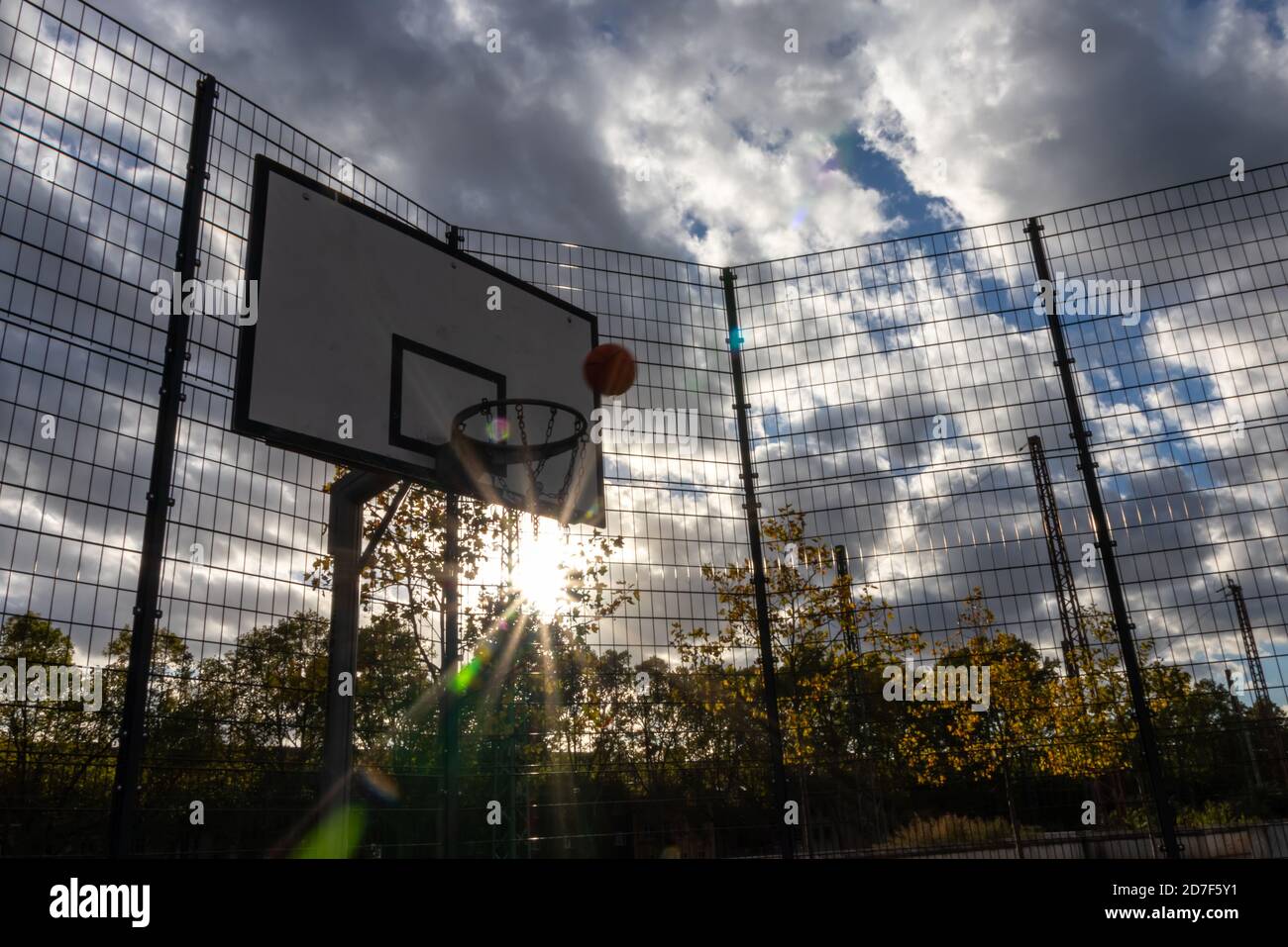 Basketball-Action mit einem fliegenden Ball aus dem Training und Üben Sie zu werfen und schlagen Sie den Basketball in den Basketball Korb für Erfolg und Sieg Stockfoto
